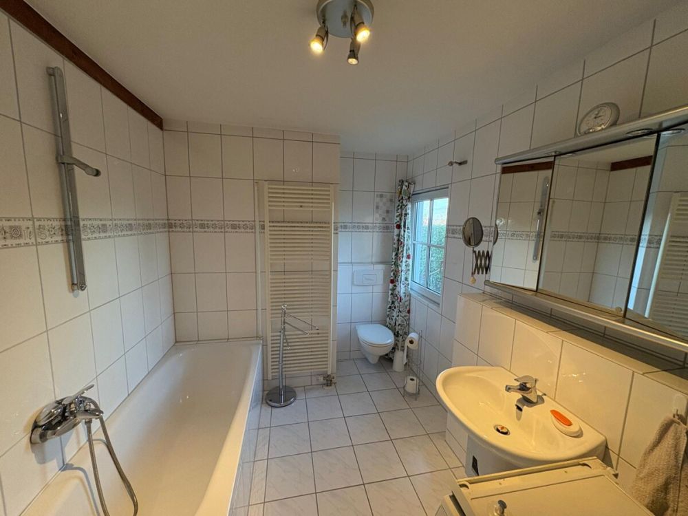 Geräumiges Fensterbad mit Wanne und Anschluss für die Waschmaschine