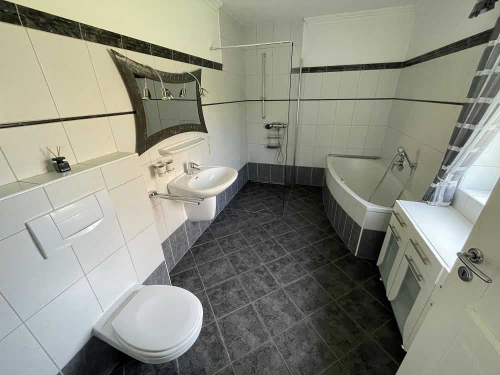 Modernes und zeitloses Tageslichtbad mit Badewanne und Dusche