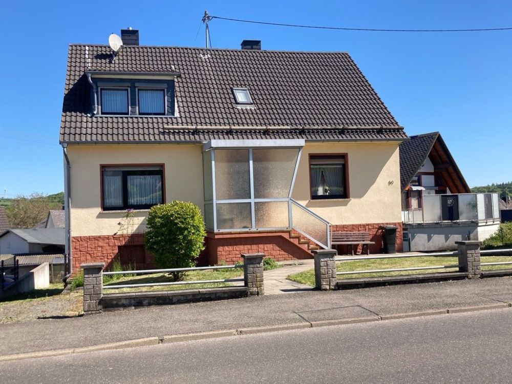 Straßenansicht mit seitlicher Zufahrt hinter das H