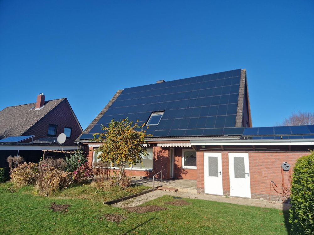 Blick auf die Photovoltaikpaneele und Zugangstüren Keller / Garage