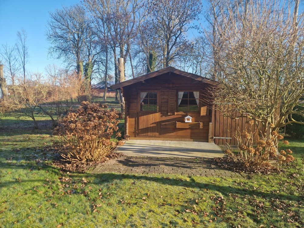 Kleines Gartenhäuschen aus Holz mit Terrasse