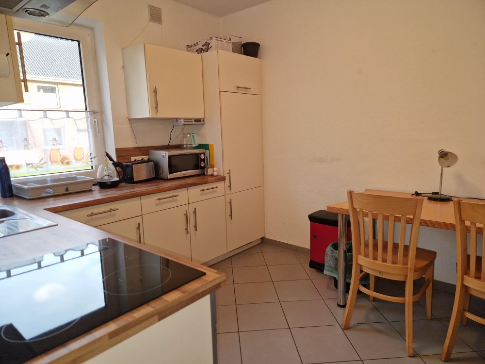 Zeitlose Einbauküche mit Platz für eine kleine Essecke